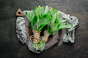 Fresh wild garlic leaves on a wooden background. Top view.