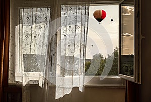 Fresh wind in the window. View from the window to the balloons