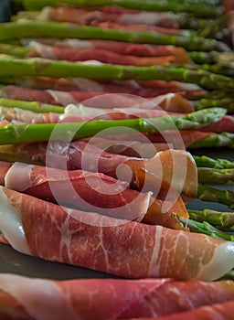 Fresh wrapped ham on delicious asparagus