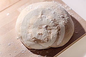 Fresh yeast dough  on wooden background, fresh raw dough on wooden board, dough ready for baking