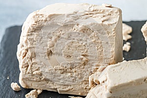 Fresh yeast on the gray table closeup. Ingredient for baking bread and bakery products