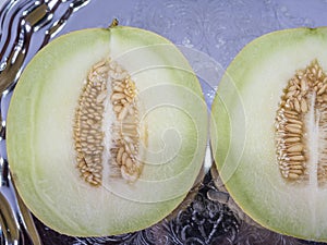 Fresh yellow cantaloupe cut in half on the old tray in closeup