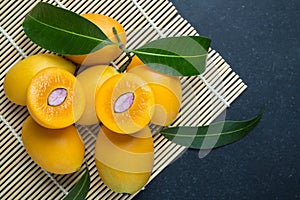 Fresh yellow marian plum fruit (Mayongchid) in Thai name) on black stone. Top view