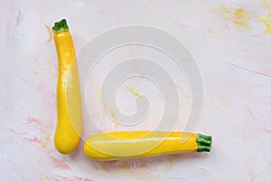 Fresh yellow squash on a pink background