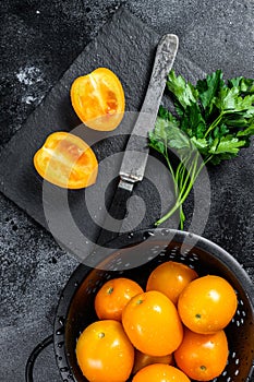 Fresh yellow tomato cut in half. Black background. Top view