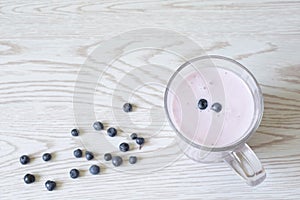 Fresh yogurt in cup with blueberries. Healthy drink. Summer fruits, berries background