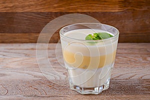 Fresh yogurt and lemon dessert. Fruit panna cotta in a glass over rustic wooden background. Copy space banner.