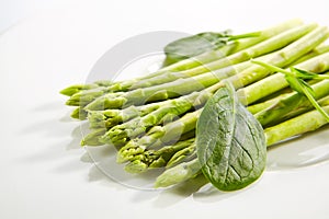 Fresh Young Asparagus Stalks and Green Spinach Leaves Isolated