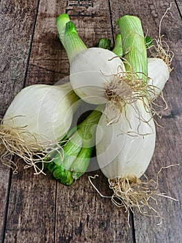 Fresh young onions on wooden table