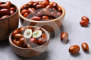 Fresh Ziziphus jujuba fruits with wooden bowls on light table