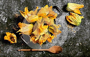 Fresh zucchini flowers inside vintage pan top view