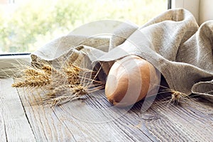 Freshly baguettes baked bread and wheat spikes on wooden background