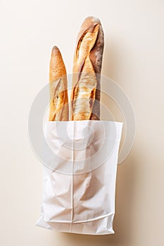 freshly baked baguette in paper bag on white background