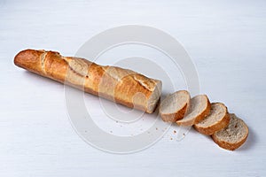 freshly baked baguette and slices on white background, top view