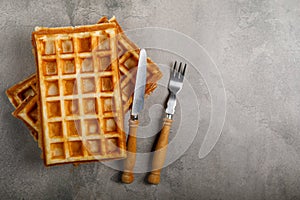 Freshly baked belgium waffles on concrete background.