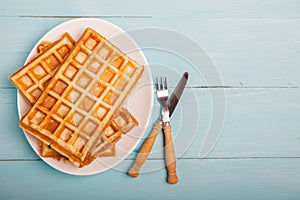 Freshly baked belgium waffles in plate. Breakfast concept with c