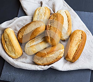 Freshly baked bread buns on a linen towel, whole bread buns heap photo