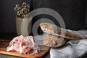 Freshly baked bread and ham on a wooden board