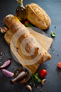 freshly baked bread on wooden cutting board on dark table