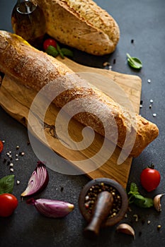 freshly baked bread on wooden cutting board on dark table