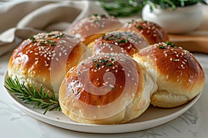 Freshly baked buns with sesame seeds on a decorative plate