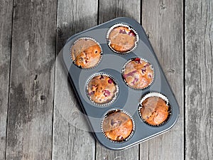 Freshly baked cherry muffins closeup in baking tray