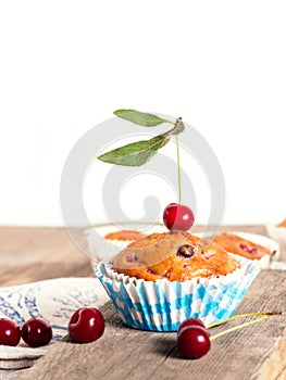 Freshly baked cherry muffins closeup on a rustic table