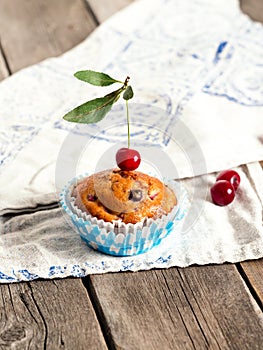 Freshly baked cherry muffins closeup on a rustic table