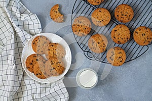 Freshly baked chip chocolate cookies and glass of milk on stone table top view