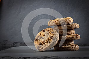 Freshly baked Chocolate chip cookies on a dark stone with place for text