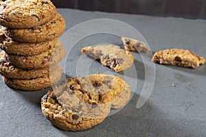 Freshly baked Chocolate chip cookies on a dark stone with place for text