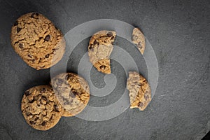 Freshly baked Chocolate chip cookies on a dark stone with place for text