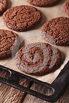 Freshly baked chocolate cookies on a baking sheet close-up. vert