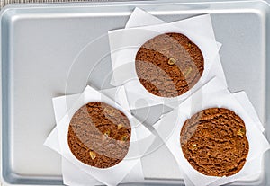 Freshly baked chocolate ginger snap cookies on the baking sheet on a table close-up.