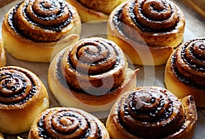 Freshly baked cinnamon buns with cacao and spices. Close-up. Sweet christmas baking. Kanelbulle - swedish dessert.