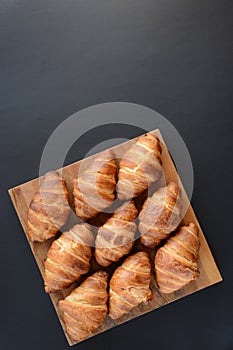 The freshly baked croissants on black background. Flat style