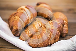 Freshly baked croissants closeup on wooden table, fresh french croissants, breakfast buns