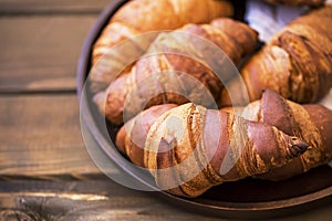 Freshly baked croissants closeup on wooden table, fresh french croissants, breakfast buns
