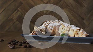 Freshly baked croissants, mint leaves and cup of coffee on wooden board, top view, selective focus