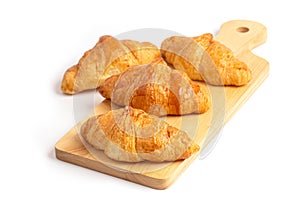 Freshly baked croissants on wooden cutting board