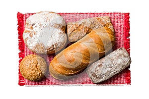 Freshly baked delicious french bread with napkin isolated on white background top view. Healthy white bread loaf