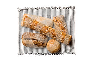 Freshly baked delicious french bread with napkin isolated on white background top view. Healthy white bread loaf