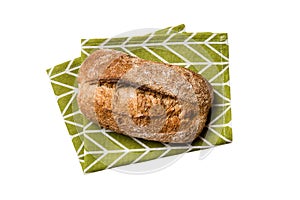 Freshly baked delicious french bread with napkin isolated on white background top view. Healthy white bread loaf