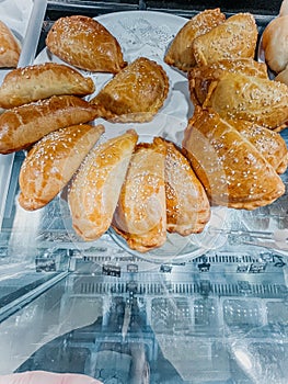 Freshly baked delicious pies on a white plate in the bakery.