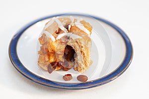 Freshly baked fruity chelsea bun on a plate with fruit. Narrow f