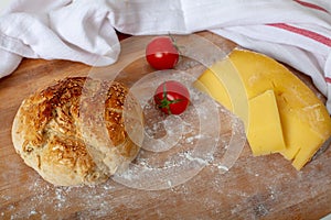 Freshly baked homemade bread with white fabric on wooden cuttin