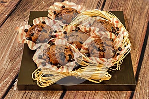 Freshly baked homemade muffins with blueberries on a black wooden plate