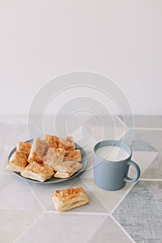 freshly baked homemade pastry on kitchen table. breakfast with puff buns and a glass of milk