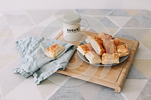 freshly baked homemade pastry on kitchen table. breakfast with puff buns and a glass of milk