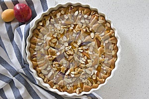 Freshly baked homemade pie with apricots and peaches on a light background. Top view, natural light